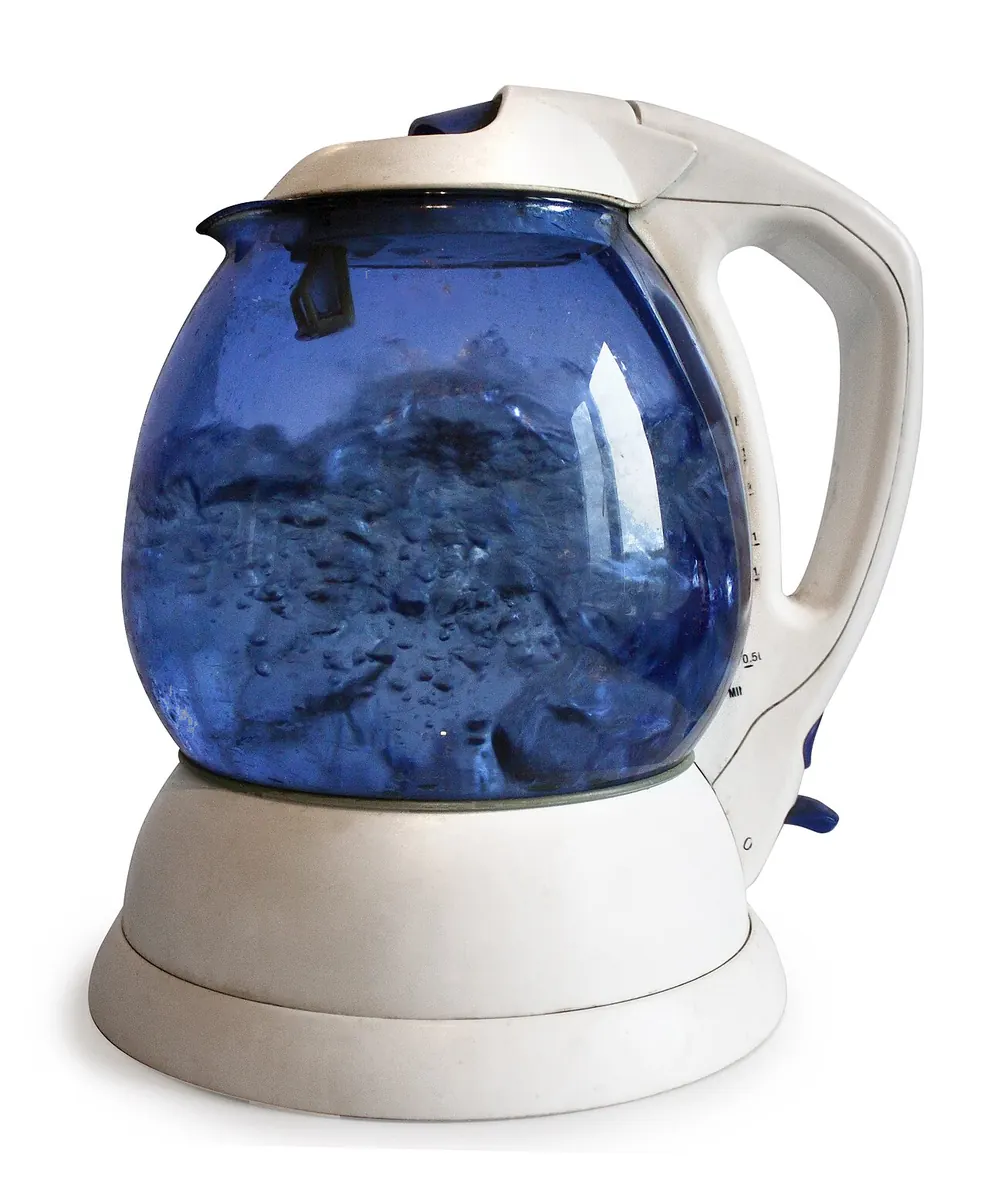 Electric kettle with a blue glass jug boiling water