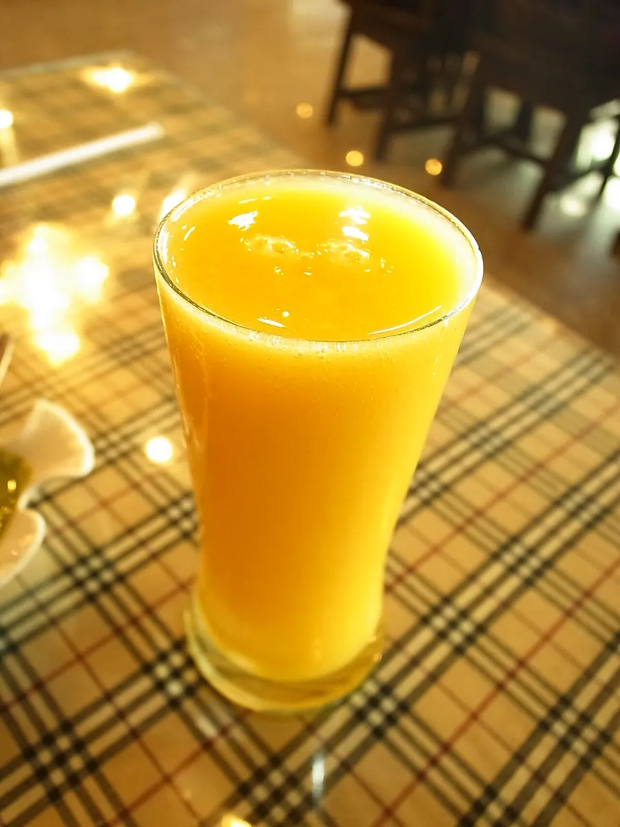 Glass of fresh mango juice on a checked tablecloth