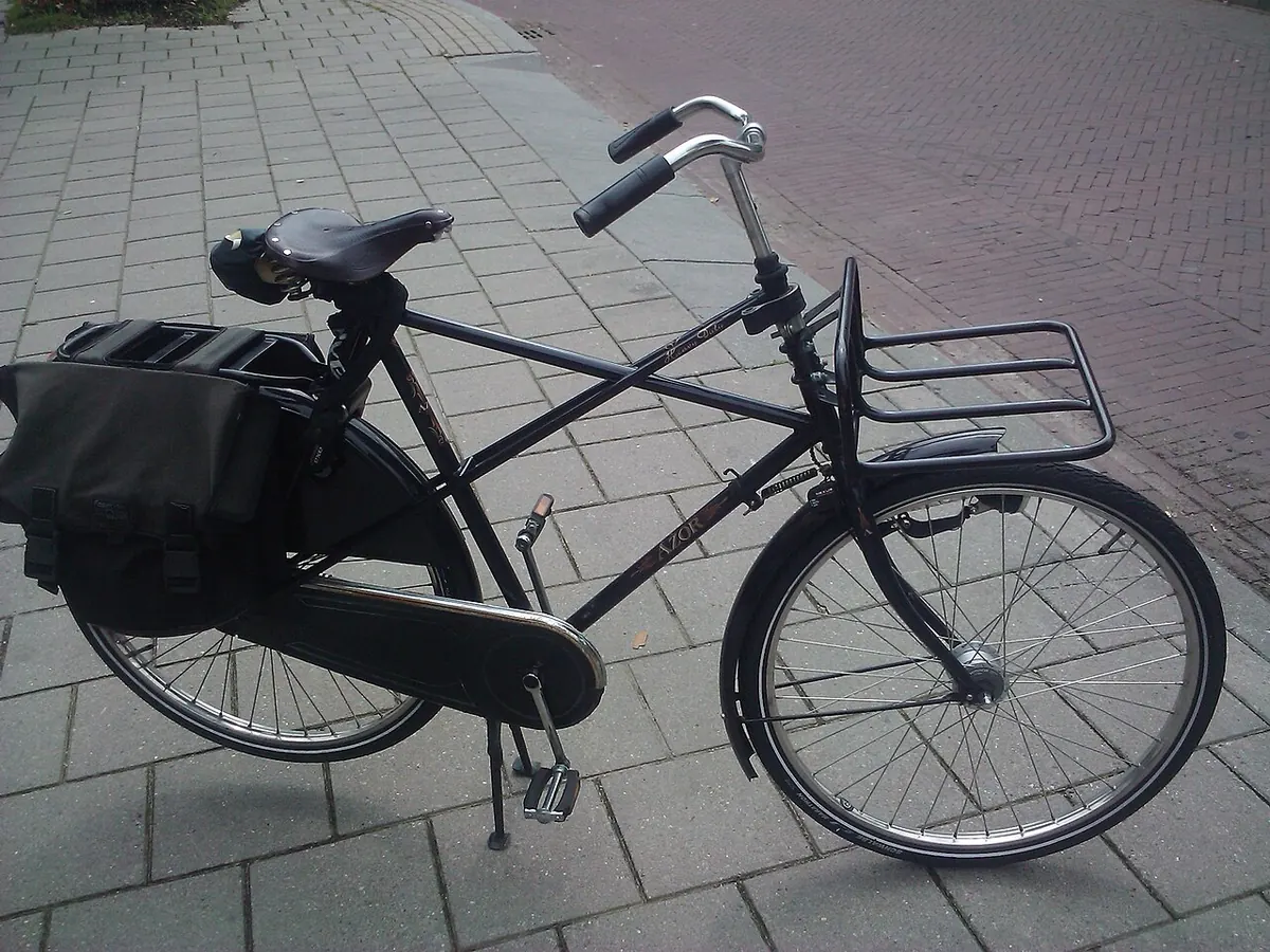 Black city bicycle with a front rack and rear pannier