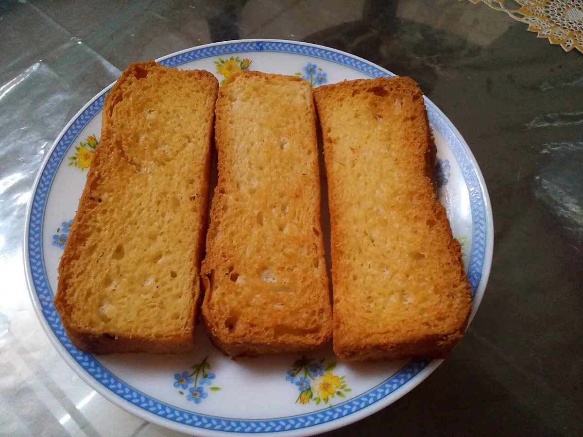 Three golden rusk slices on a patterned plate