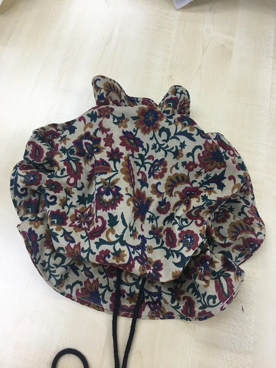 Floral print bucket hat with a drawstring on a desk