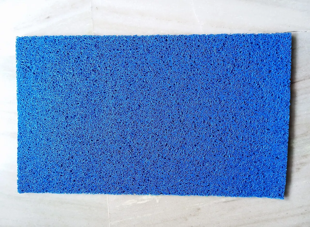 Blue PVC coil door mat on a white floor