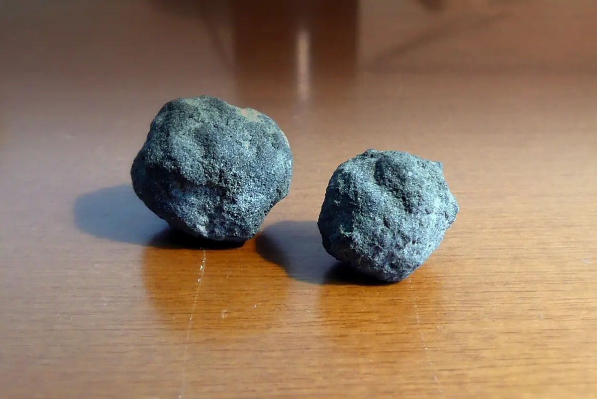 Two round cement clinker nodules on a table