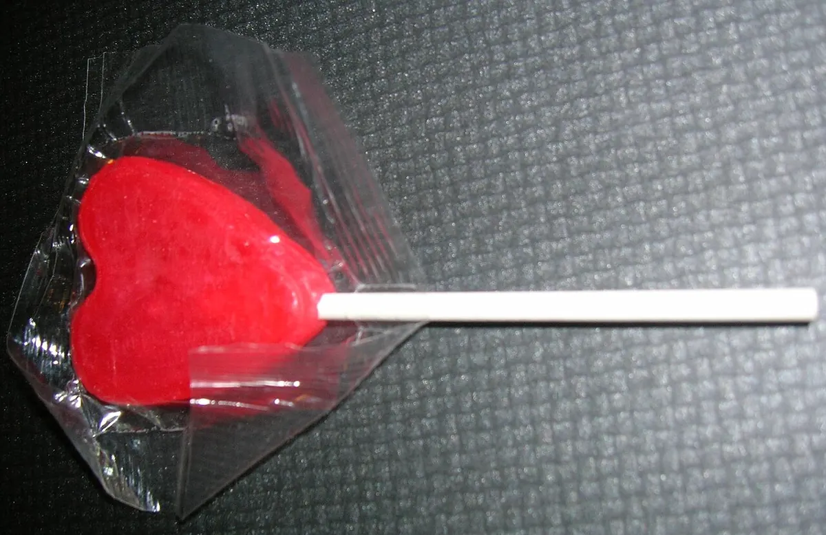 Red heart shaped lollipop in a clear wrapper