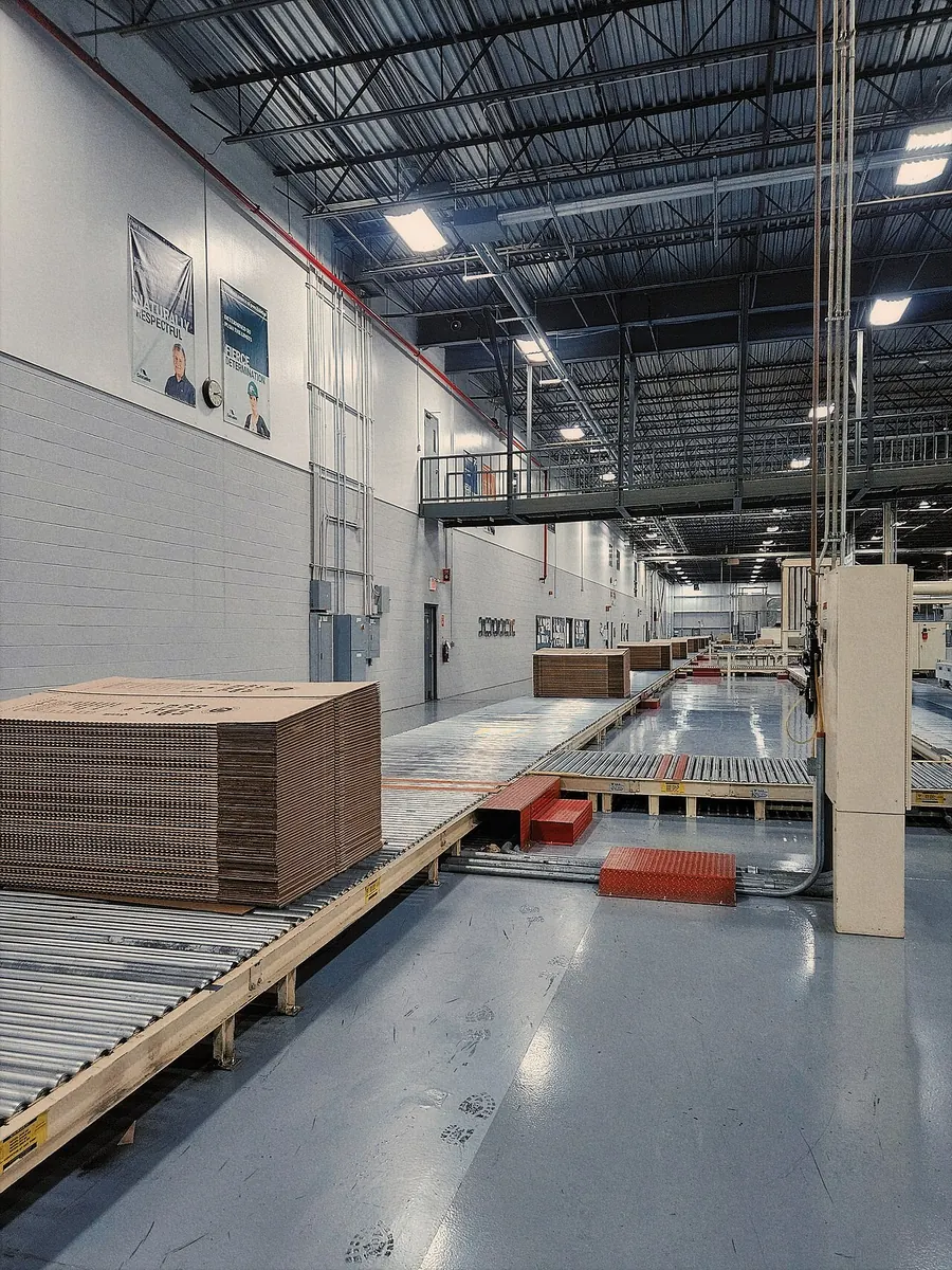 Corrugated board sheets moving along a factory conveyor