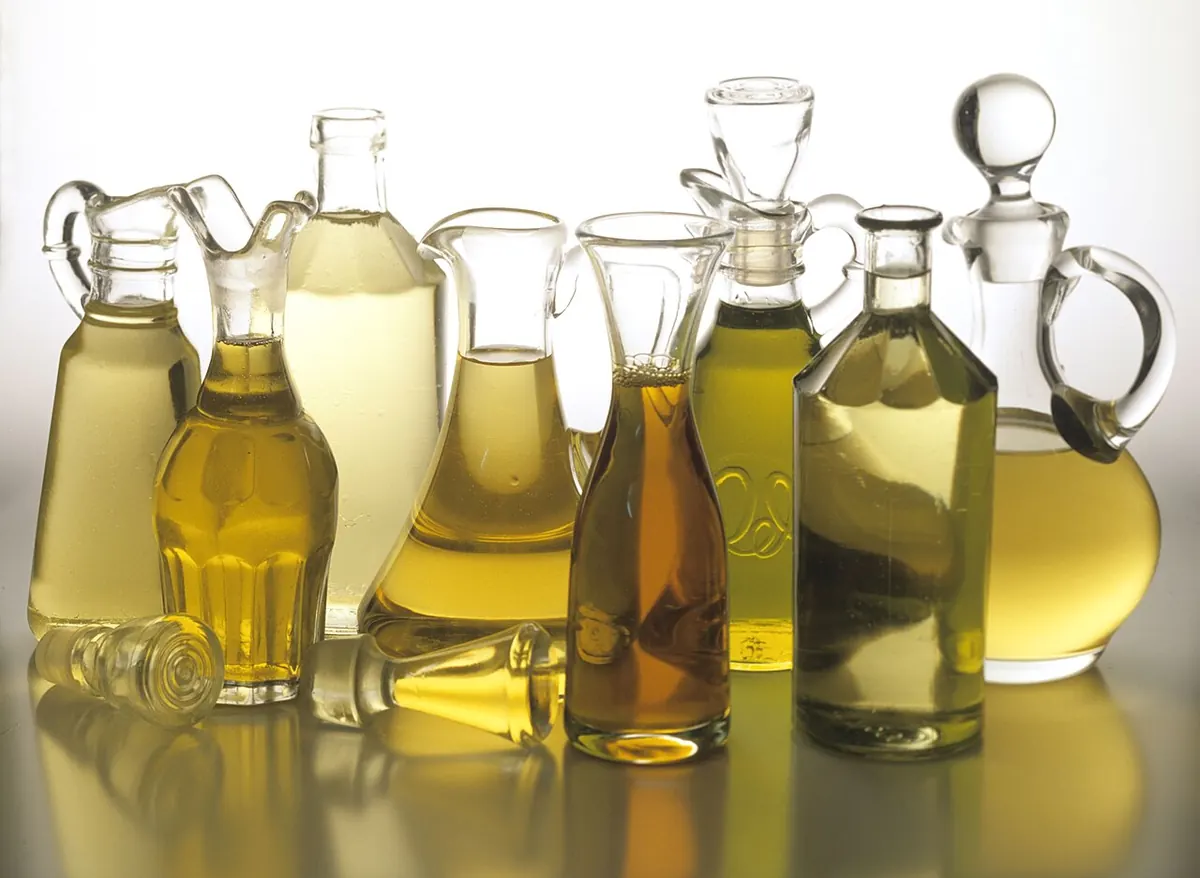 Assorted cooking oils in clear glass bottles and jugs