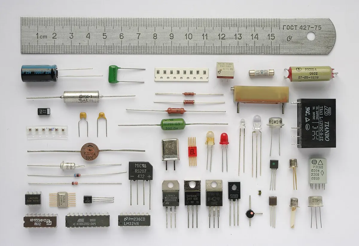 Assorted electronic components laid out beside a steel ruler