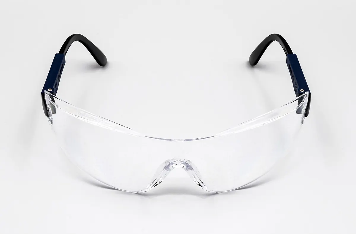 Clear safety glasses with dark blue arms on a white background