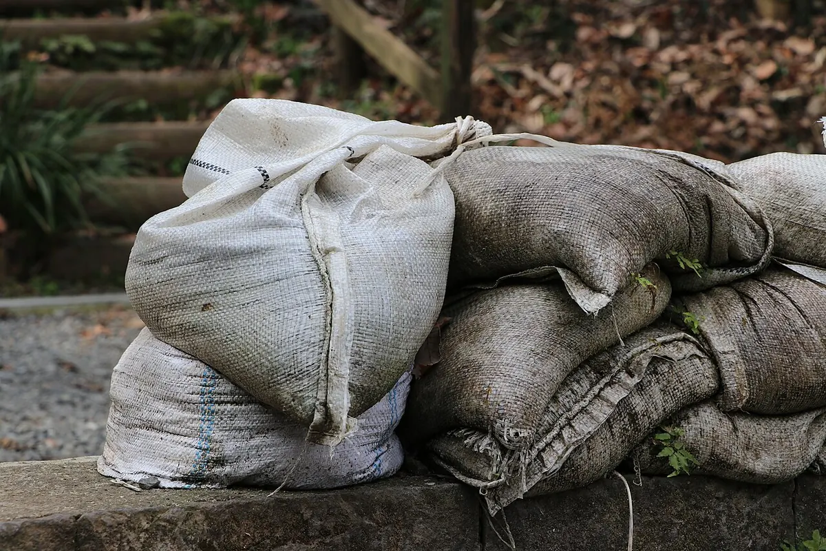 Stacked woven polypropylene sandbags on a low wall