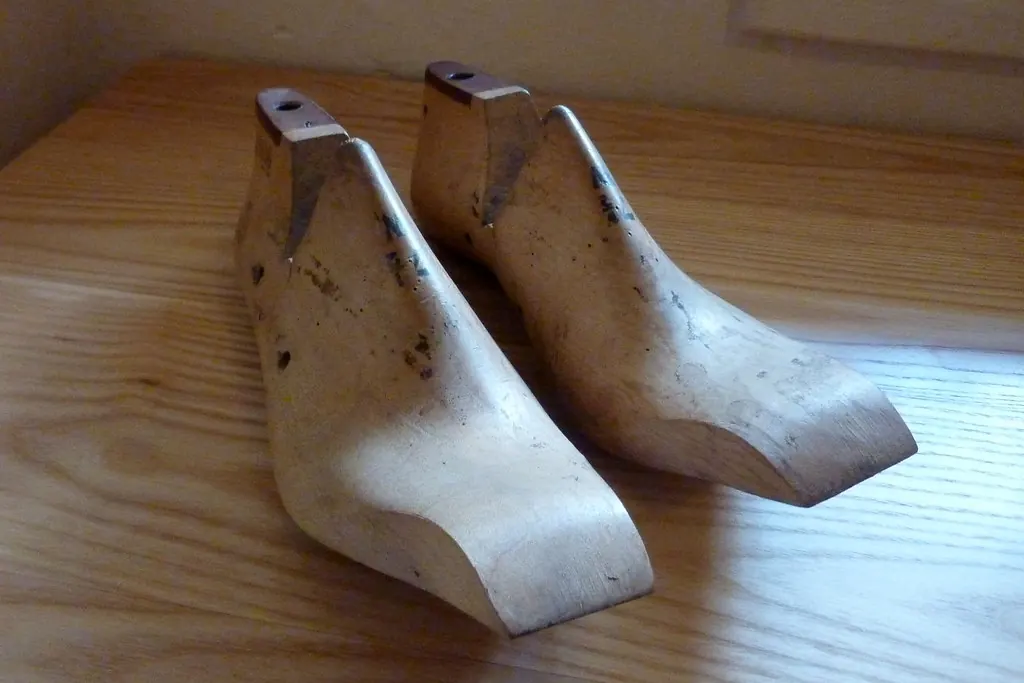 Pair of wooden shoe lasts on a wooden table
