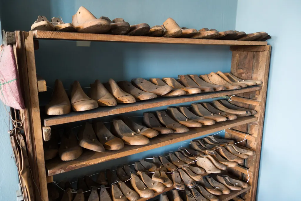 Rows of wooden shoe lasts on an old wooden rack