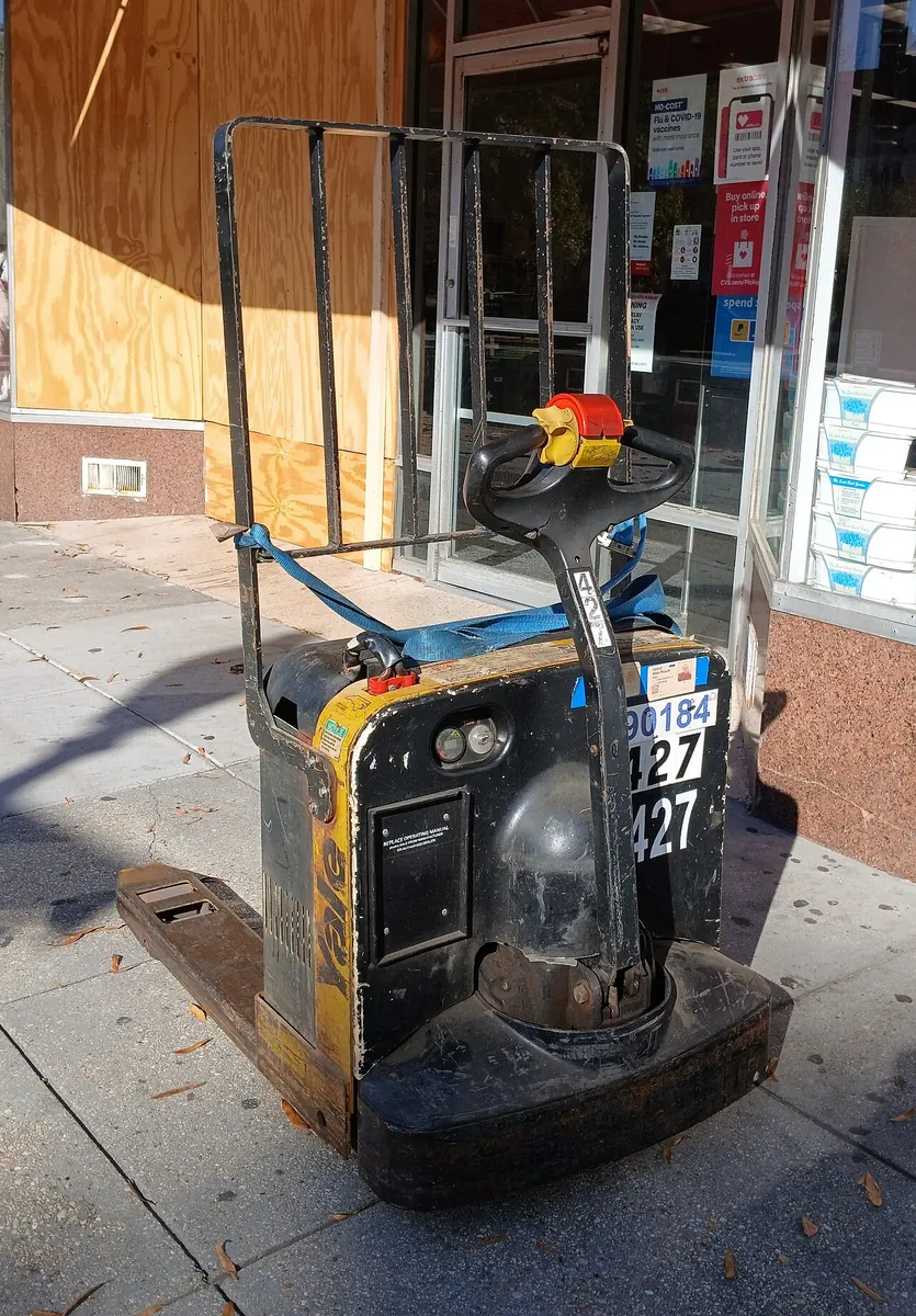 Electric pallet truck parked on a pavement