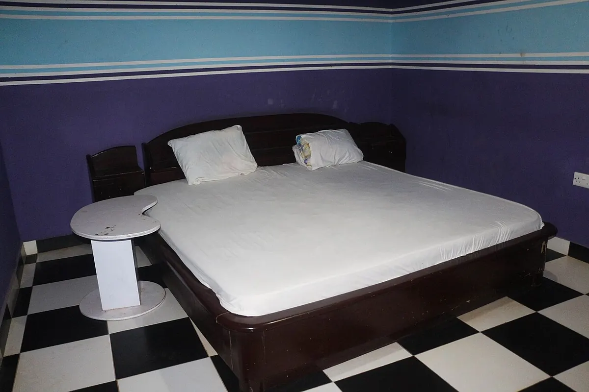 Double bed with white sheets in a guesthouse bedroom