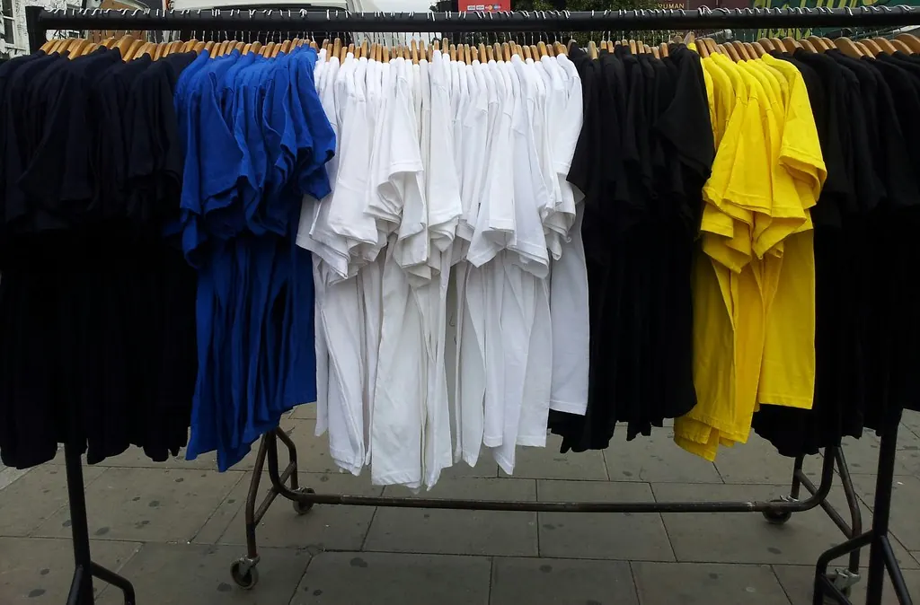 Plain T-shirts in black, white, blue and yellow on a rail