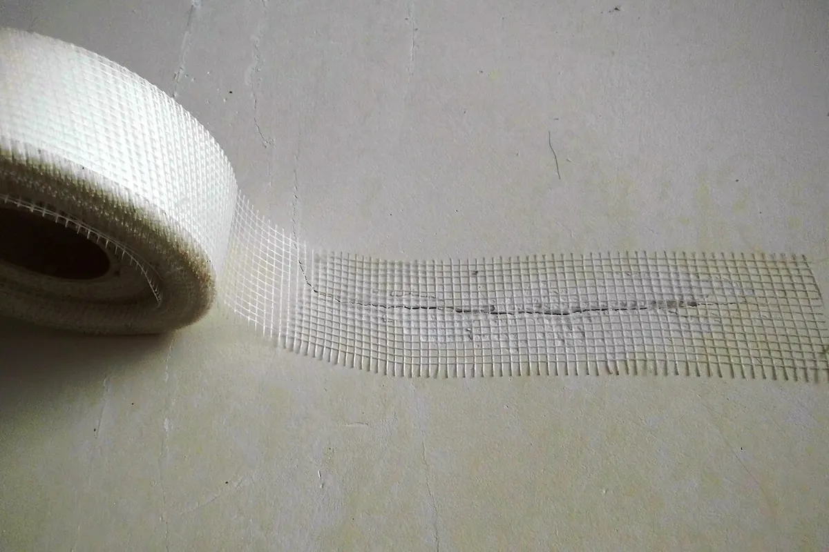 Roll of white glass fibre mesh tape on a wall