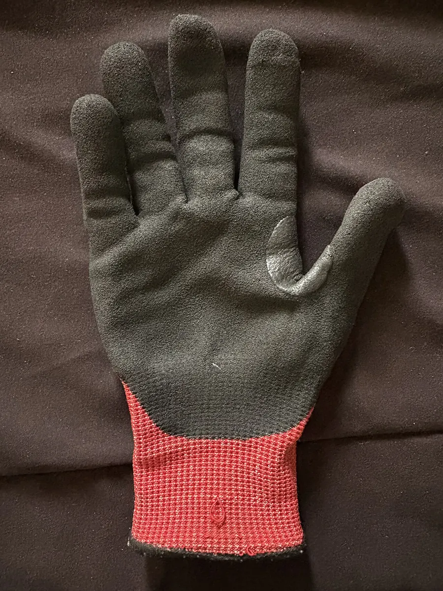 Cut resistant knitted glove with a black nitrile palm coating