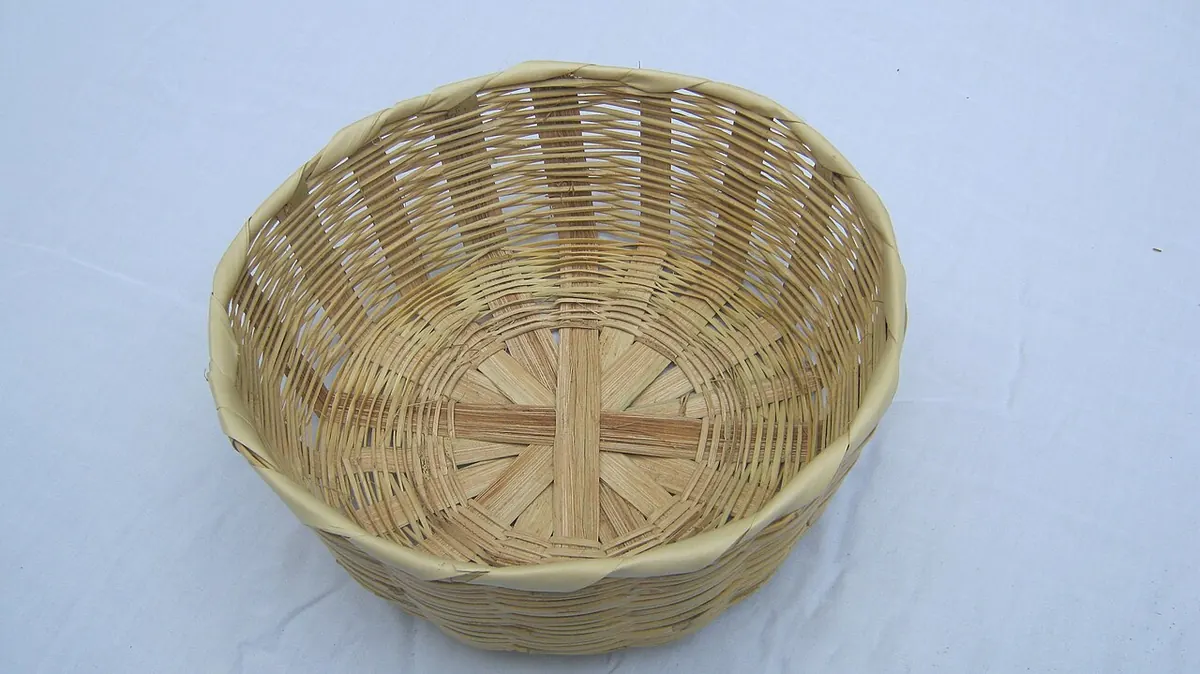 Open woven cane basket on a light grey surface
