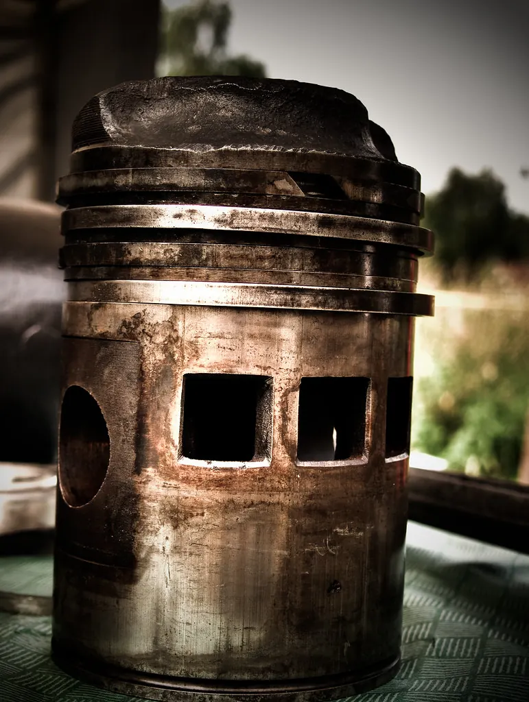 Worn engine piston with rings on a green cloth