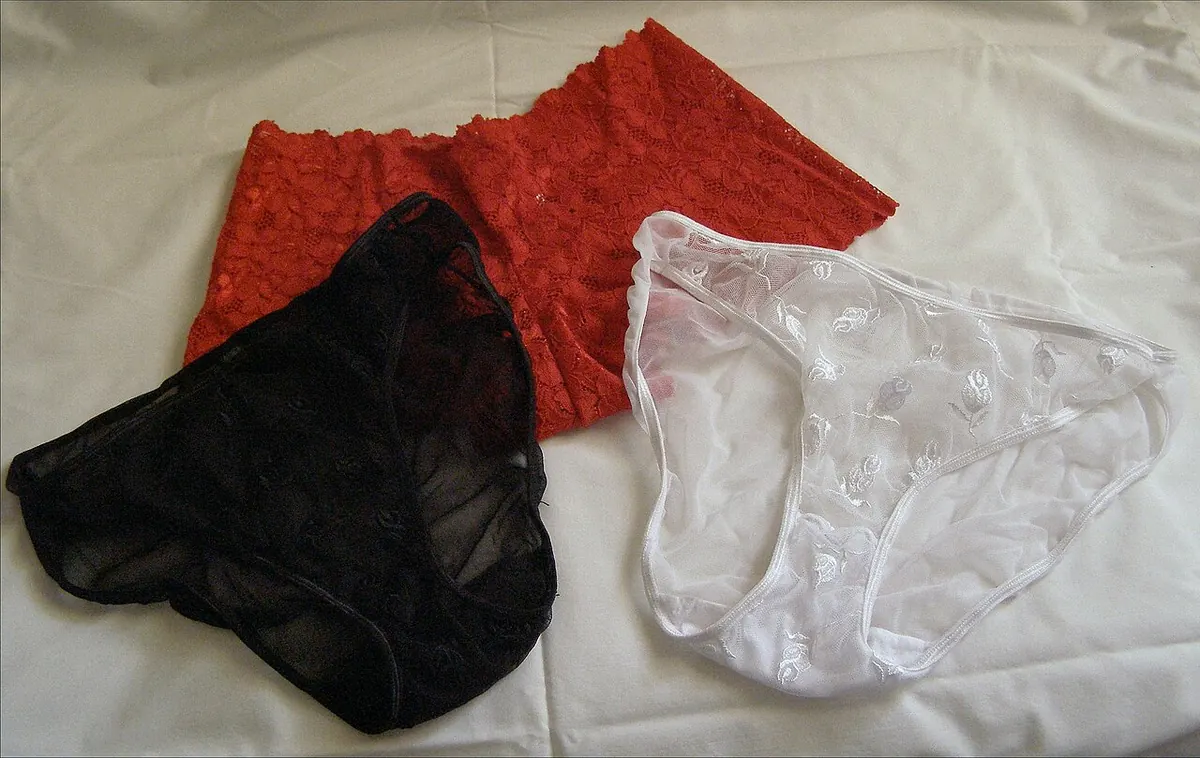 Three lace panties in red, black and white laid flat