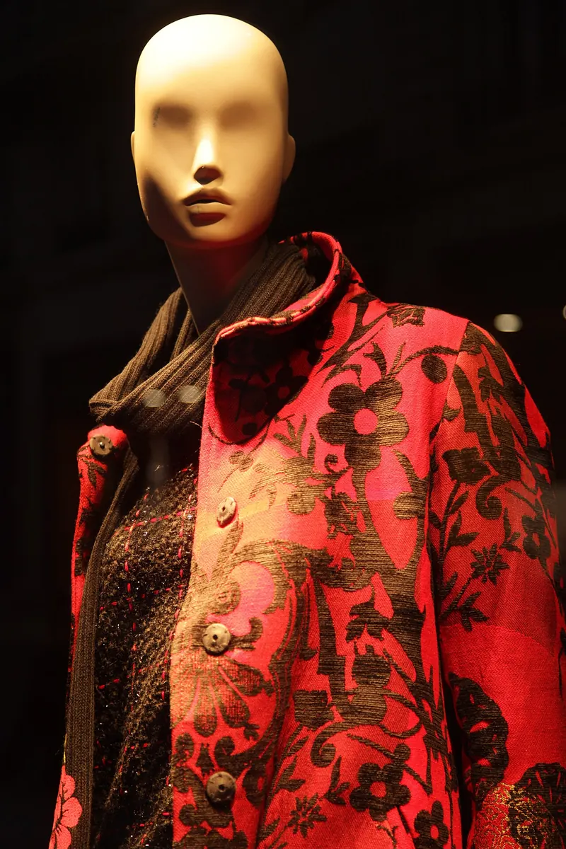 Abstract female mannequin wearing a red floral coat