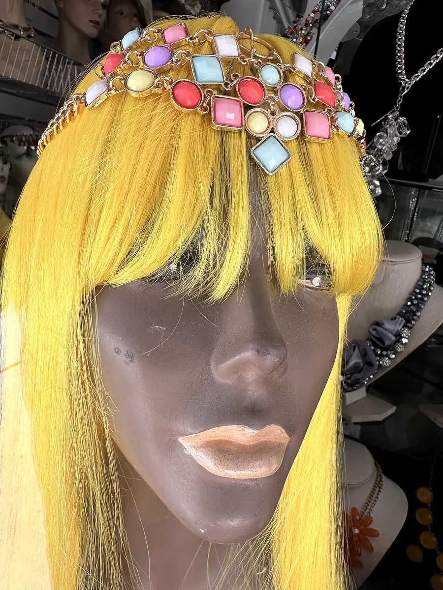 Mannequin display head with a yellow wig and jewelled headband