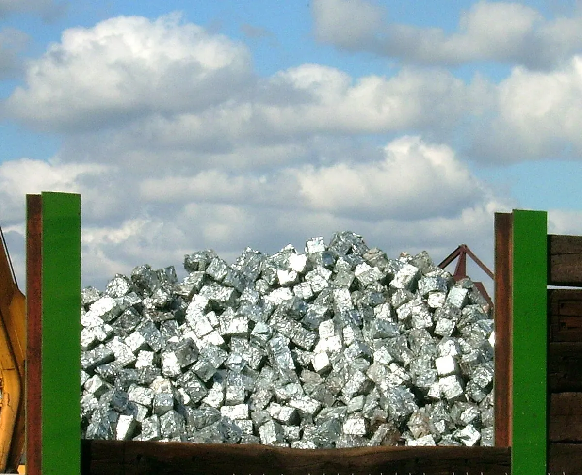 Pile of aluminium scrap pieces in a steel bin