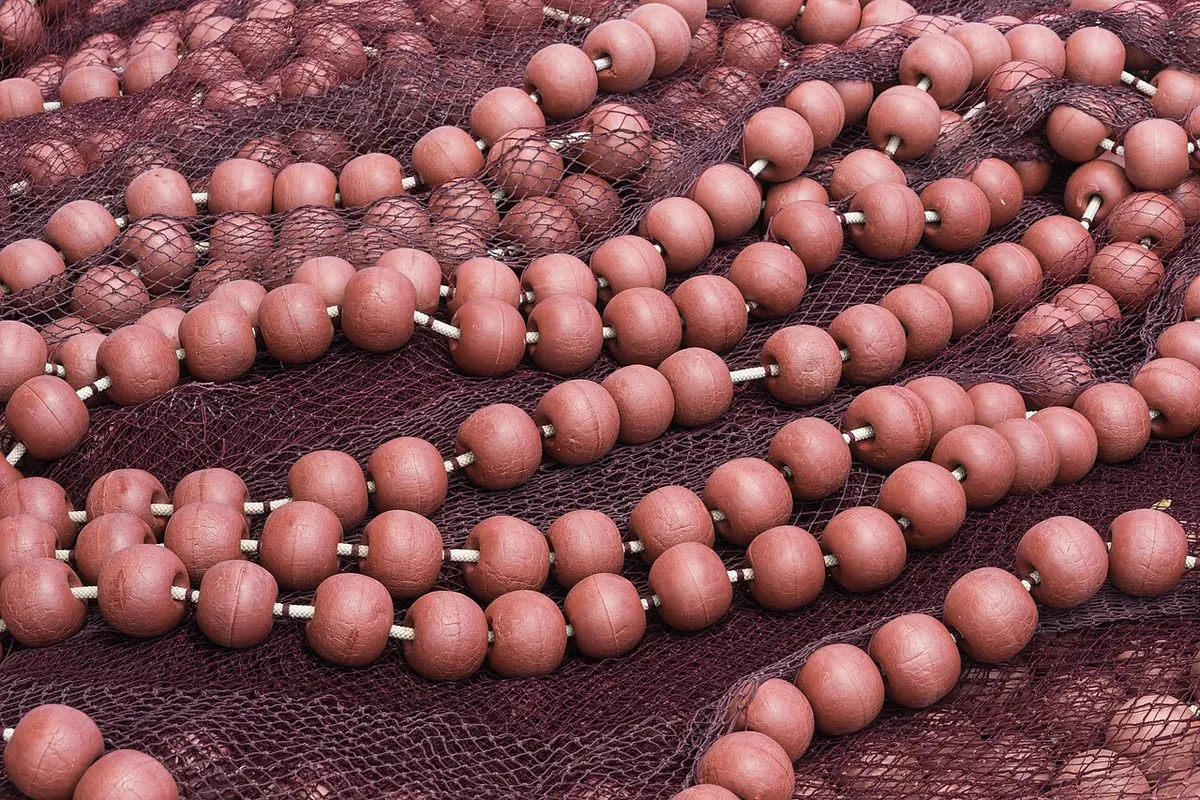 Red fishing net with rows of round pink floats