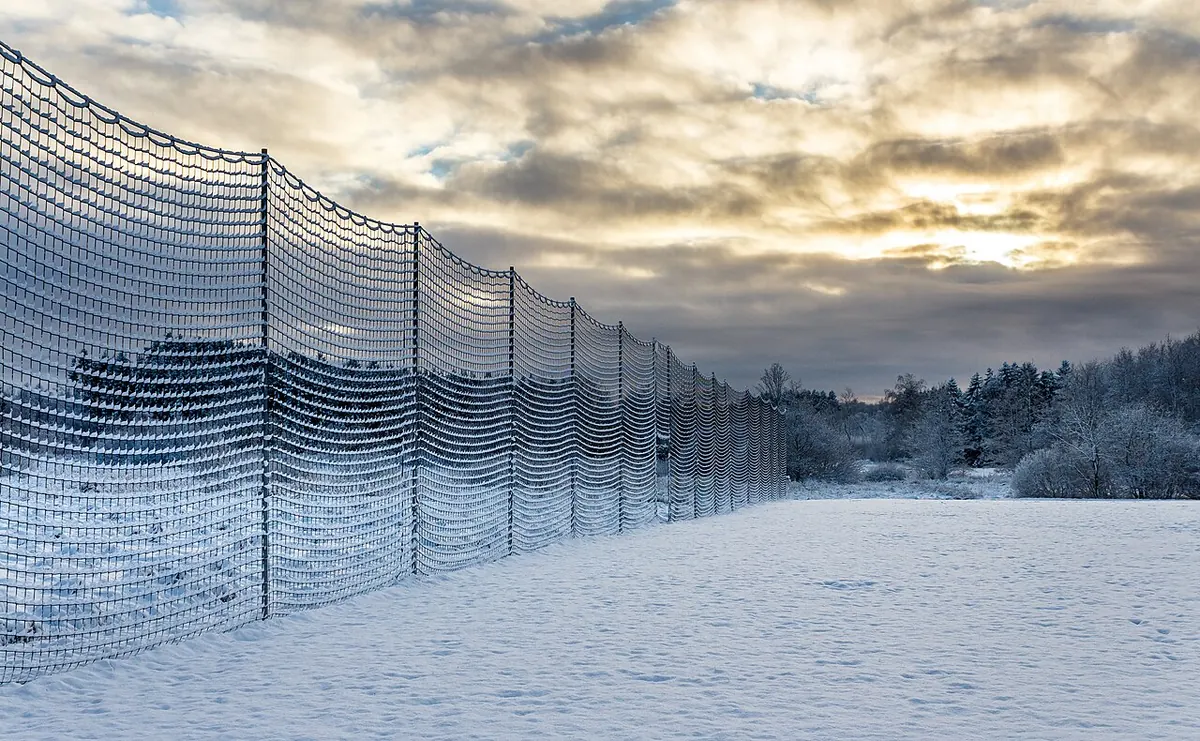 Sports safety net fence beside a snow covered field