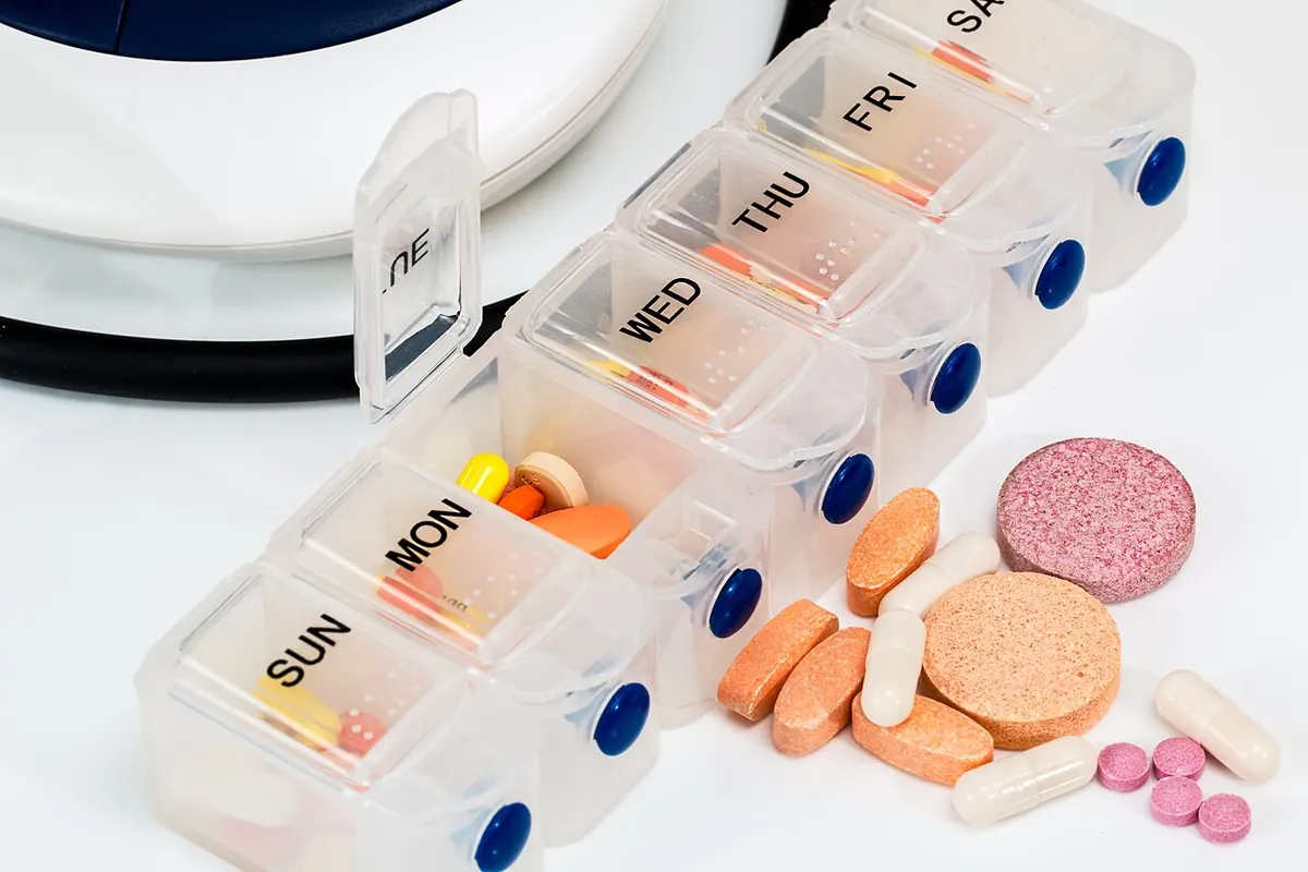 Weekly pill organiser holding assorted tablets and capsules