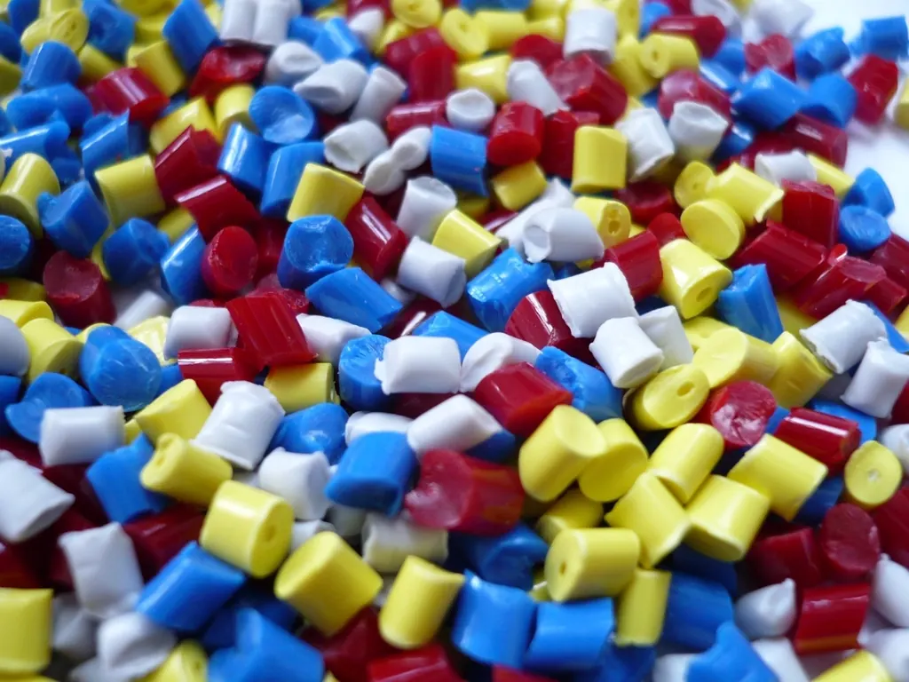 Red, yellow, blue and white plastic granules in a heap