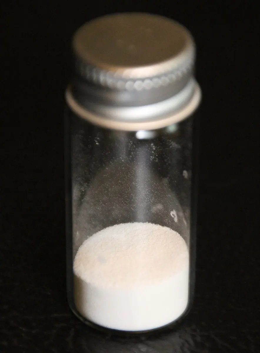 White PVC resin powder in a small glass vial