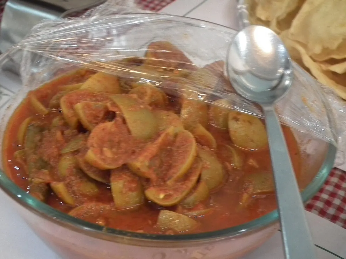 Lemon pickle in a glass bowl with a spoon