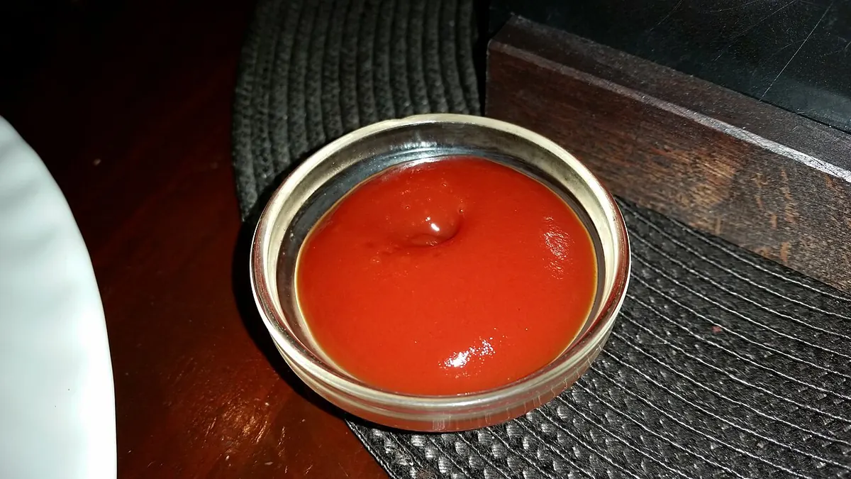 Small steel bowl of tomato ketchup