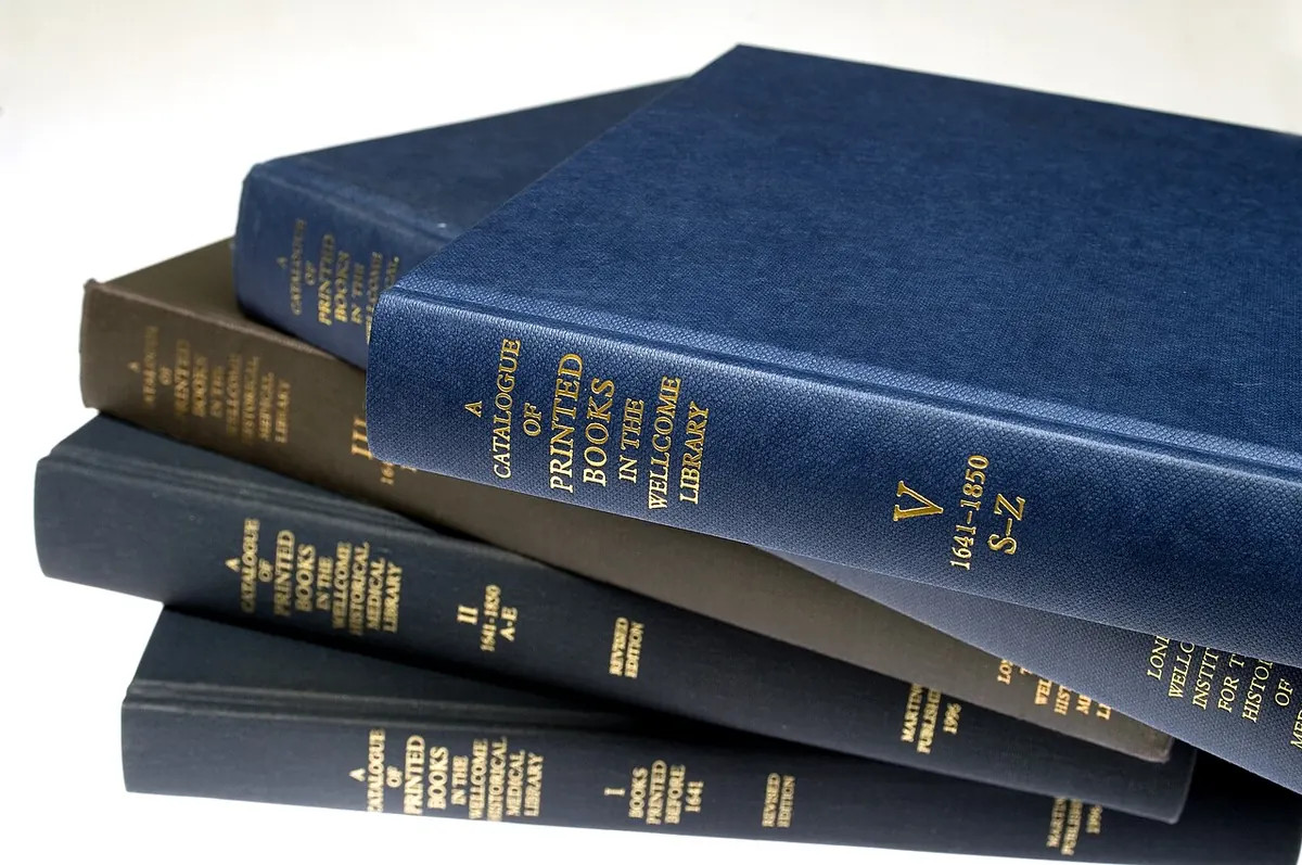 Stack of blue and brown hardback books with gilt spines