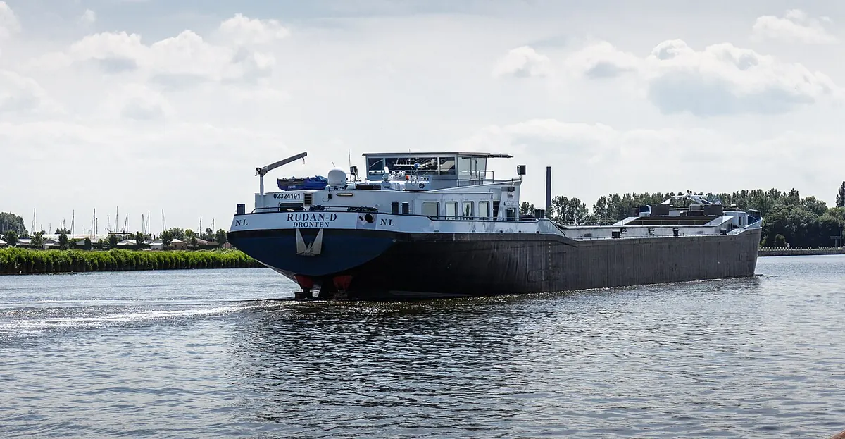 Dry cargo ship underway on a wide canal