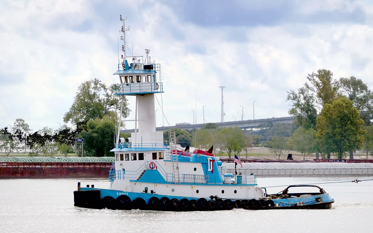 Blue and white river tug underway on a wide river