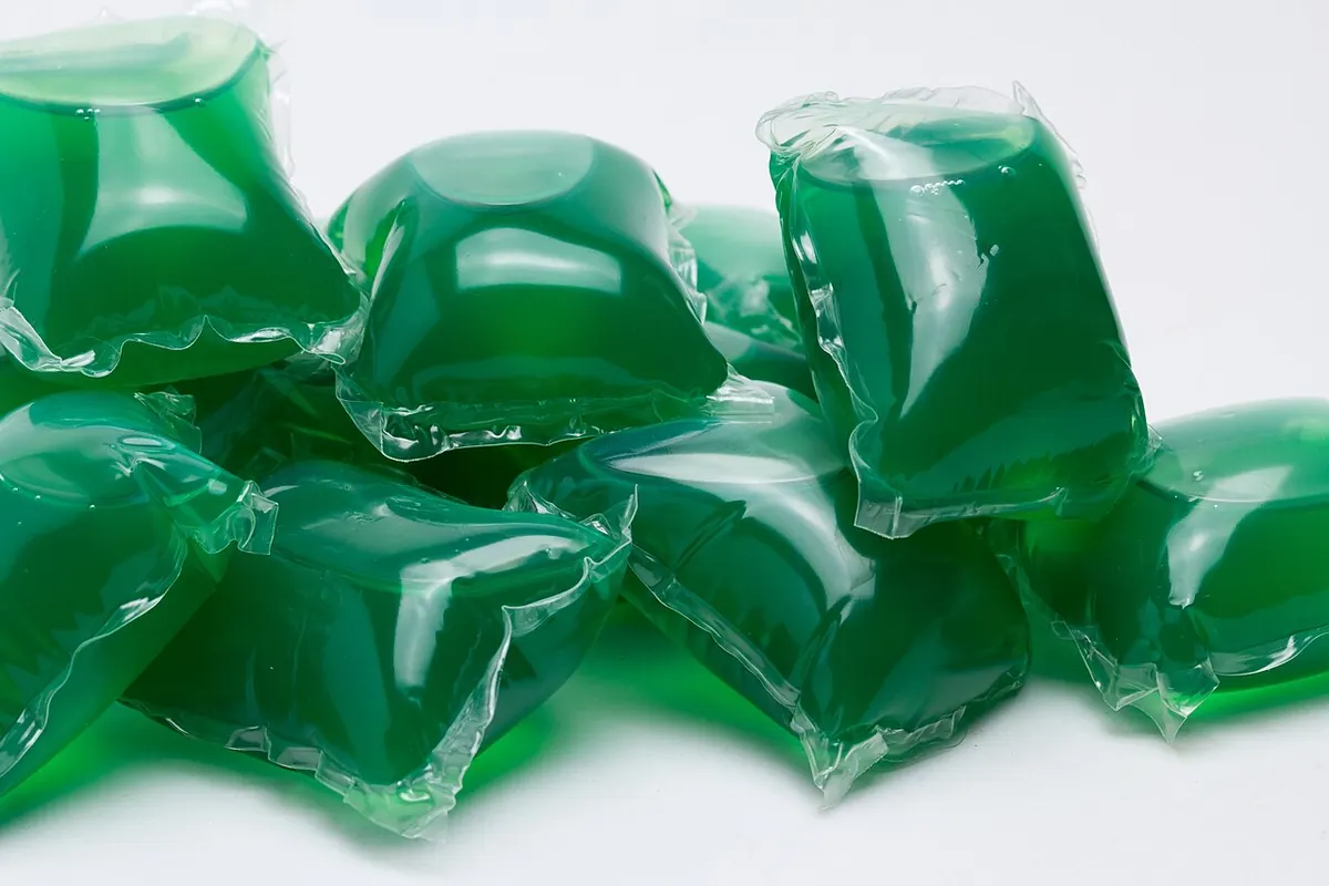 Green liquid laundry detergent pods on a white background