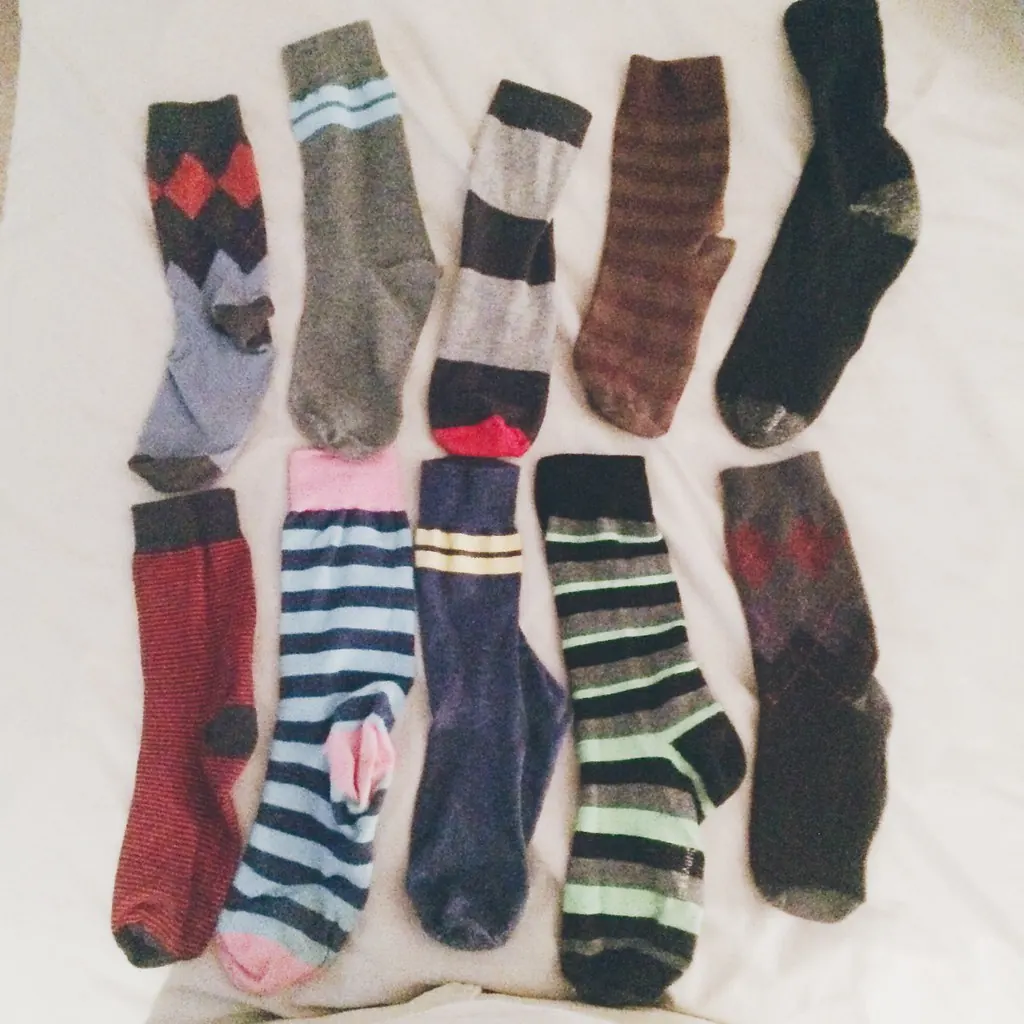 Ten odd striped and argyle socks laid flat on a sheet