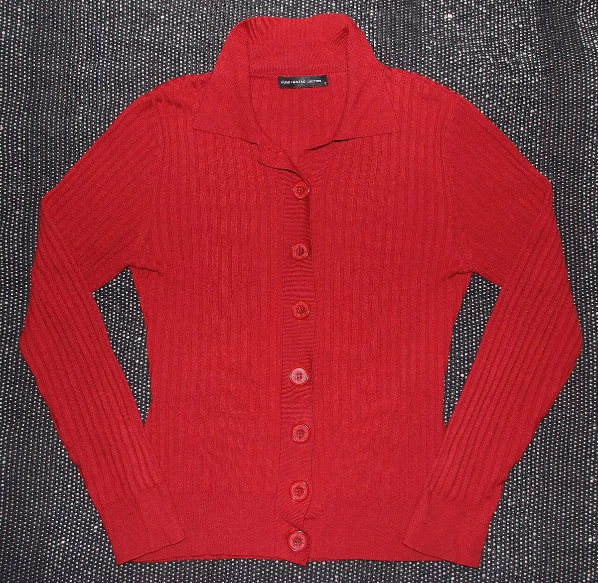Red ribbed knit cardigan with buttons laid flat