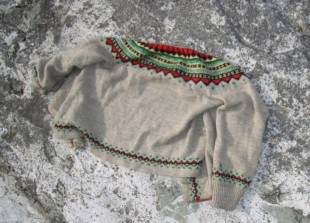 Grey knitted pullover with a patterned yoke on stone