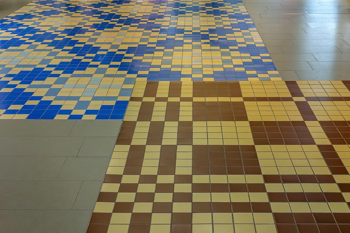 Floor laid with small blue, yellow and brown ceramic tiles