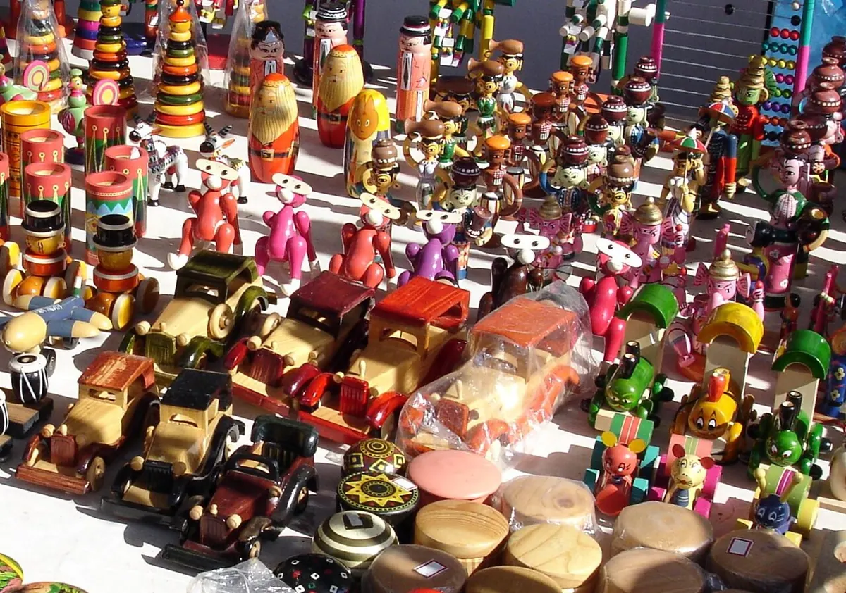 Display of brightly lacquered wooden toy cars and figures