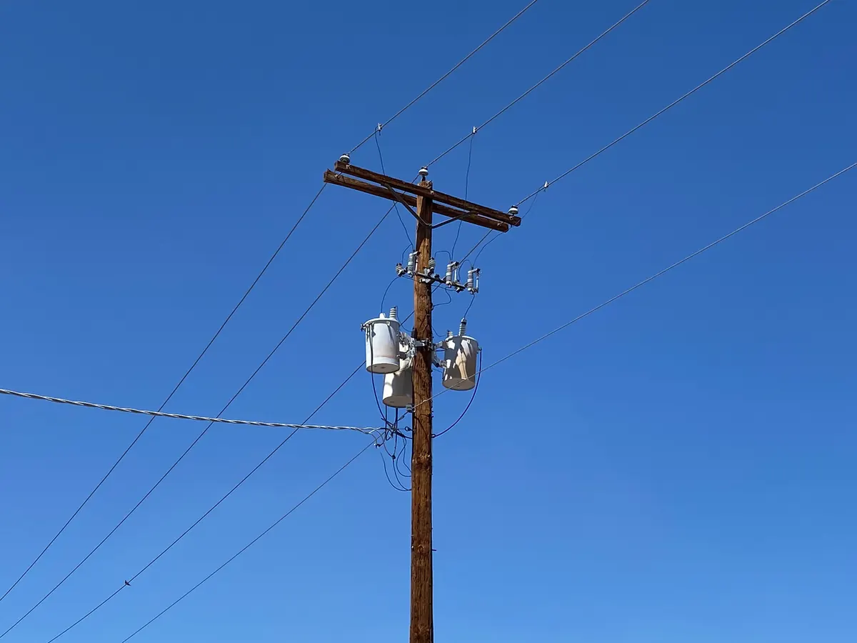 Three distribution transformers mounted on a wooden pole