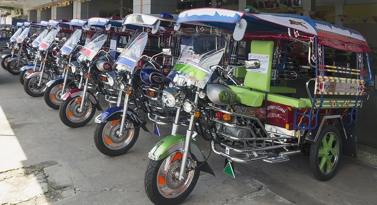 Row of new motorcycle three wheelers parked outside a shop