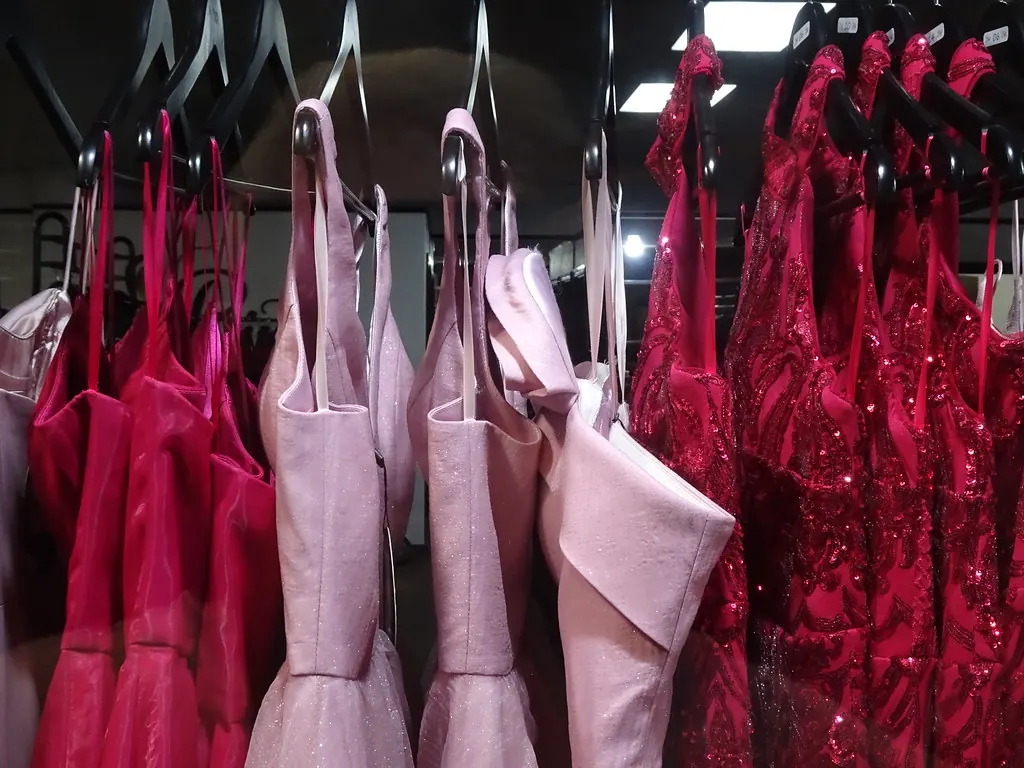 Pink satin and red sequinned party dresses on a rail