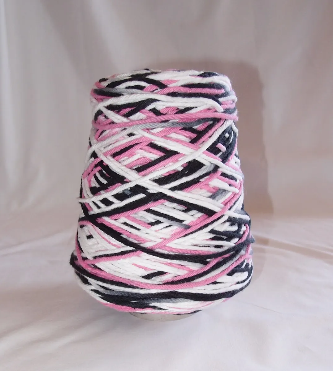 Cone of pink, black and white cotton yarn